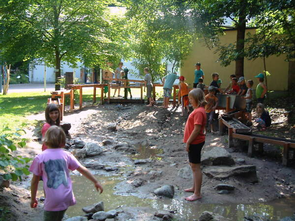 Kinder spielen Barfuß auf dem Wasserspielplatz am Naturpark-Haus in Leutenberg.