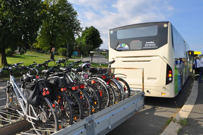 Ejn Bus der KomBus GmbH zieht einen Anhänger voller Fahrräder.